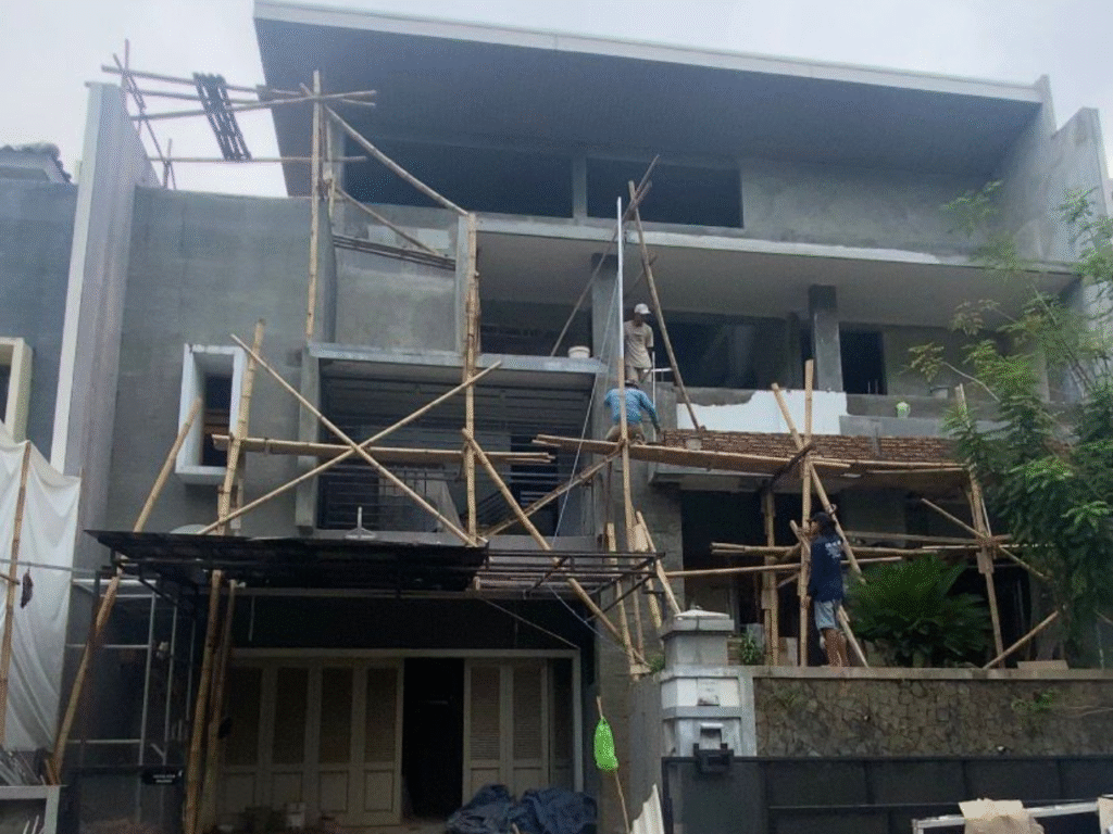 Proses renovasi rumah 2 lantai dengan pekerja konstruksi dan scaffolding bambu di area fasad